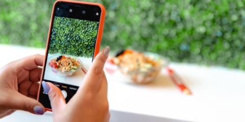 Person takes photo of poke bowl