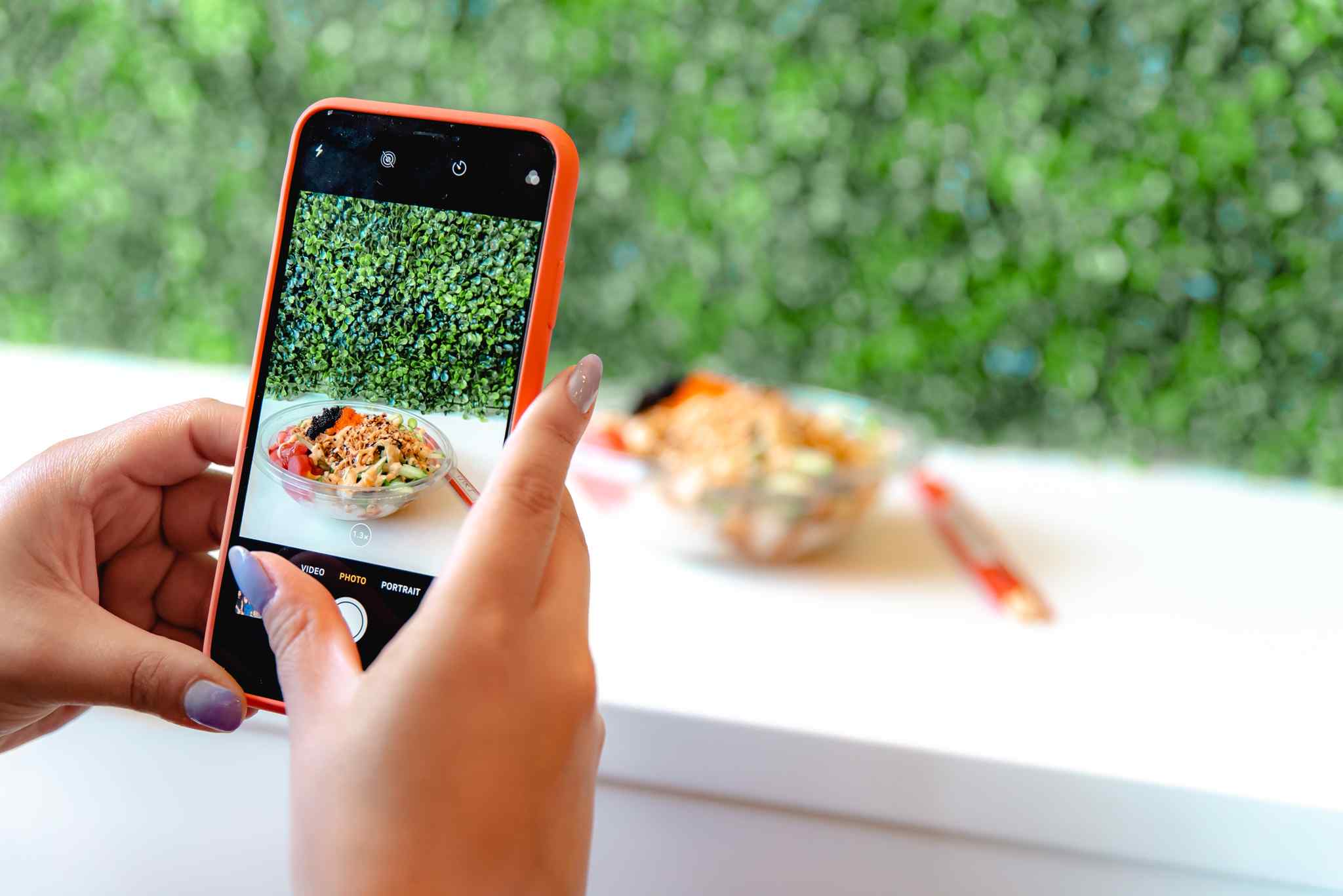 Person takes photo of poke bowl